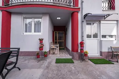 a front porch of a house with a table and chairs at Apartmani Kaan in Podgorica