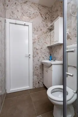 a bathroom with a white toilet and a sink at Apartmani Kaan in Podgorica