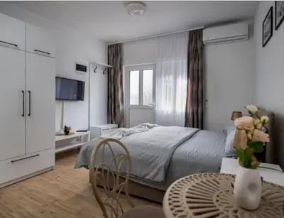 a bedroom with a bed and a table and chairs at Apartmani Kaan in Podgorica