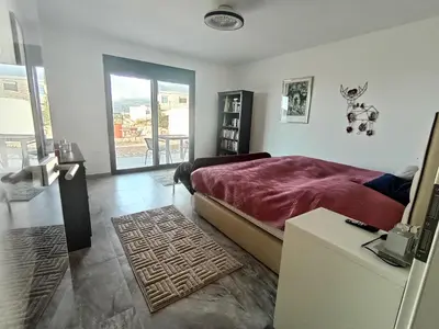 a bedroom with a bed and a door to a balcony at Studios Panoramablick Bar in Bar