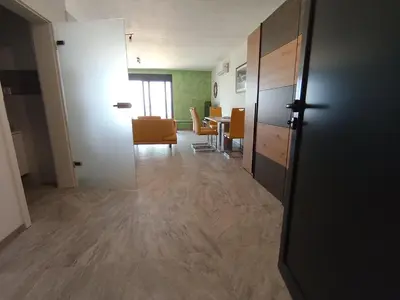 an empty room with a hallway with a table and chairs at Studios Panoramablick Bar in Bar