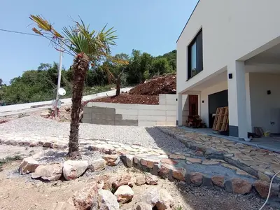 a palm tree in front of a house at Studios Panoramablick Bar in Bar