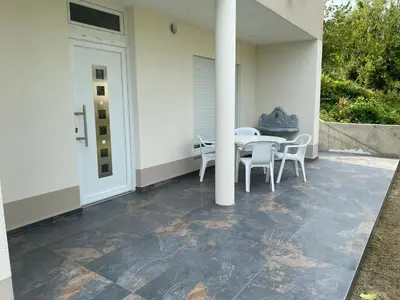 a patio with a table and chairs on a house at Apartments David in Ulcinj