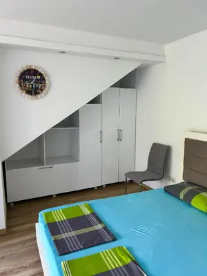 a bedroom with a bed and a chair in it at Apartments David in Ulcinj