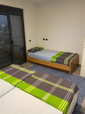 two beds in a room with green and brown blankets at Apartments David in Ulcinj