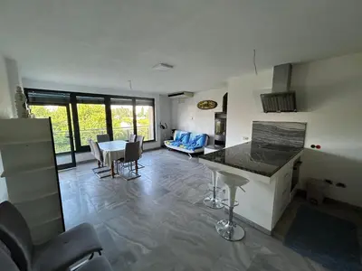 a kitchen and living room with a table and chairs at Apartments David in Ulcinj