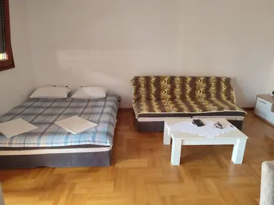 a room with two beds and a table in it at Studio Vanja in Budva