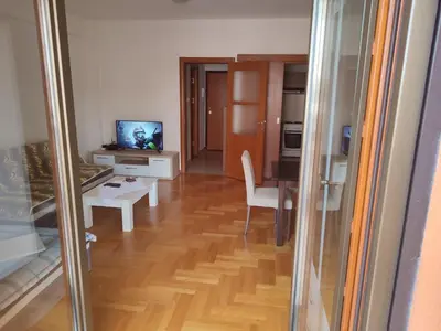 a living room with a table and a television at Studio Vanja in Budva