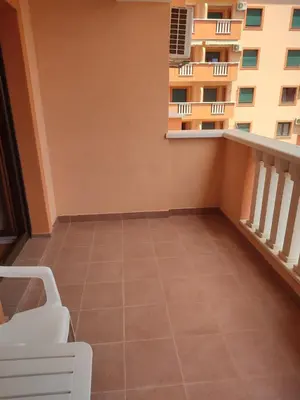 a balcony with a white chair and a building at Studio Vanja in Budva