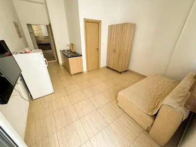a small room with a bed and a refrigerator at Biser Apartmani in Dobra Voda