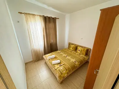 a small bedroom with a bed and a window at Biser Apartmani in Dobra Voda