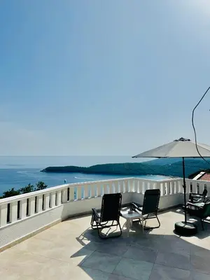 a patio with two chairs and a table and an umbrella at Budva Felix Suites in Budva
