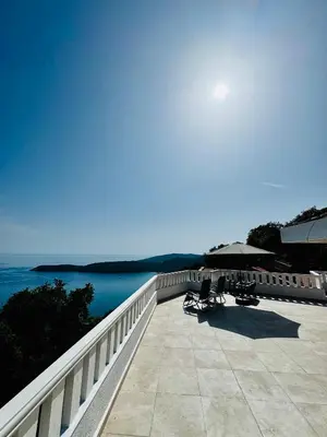 a balcony with chairs and an umbrella and the water at Budva Felix Suites in Budva