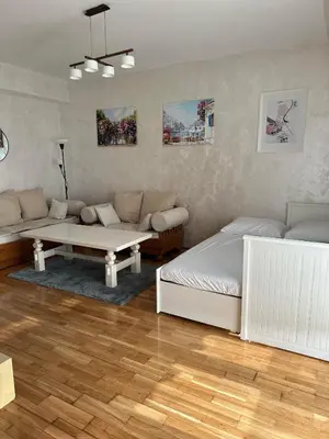 a living room with two beds and a table at Due Sorelle in Podgorica