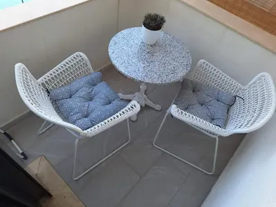 two wicker chairs and a table with a potted plant at Kupidon in Dobra Voda