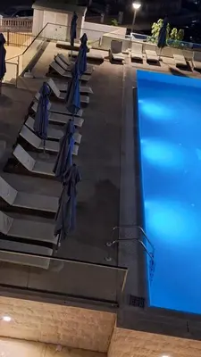 a pool with umbrellas and chairs next to a swimming pool at Kupidon in Dobra Voda