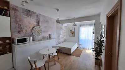 a living room with a table and chairs and a kitchen at Kupidon in Dobra Voda