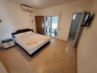 a bedroom with a bed and a television in it at Aldina Apartments in Ulcinj