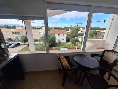 a room with a table and chairs and a large window at Aldina Apartments in Ulcinj