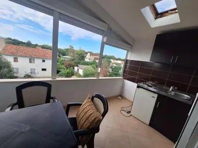 a kitchen with a table and chairs and a window at Aldina Apartments in Ulcinj
