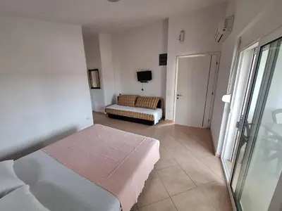 a bedroom with a bed and a couch in a room at Aldina Apartments in Ulcinj