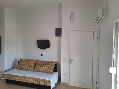 a room with a bed and a tv on the wall at Aldina Apartments in Ulcinj