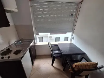 a kitchen with a table and a sink and a window at Aldina Apartments in Ulcinj