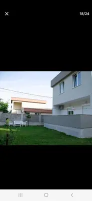 a white building with a bench in front of it at Family house Grbalj in Kotor