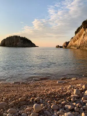 a pebble beach on the shore of a body of water at Villa Lila in Utjeha
