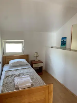 a bedroom with a bed with a wooden frame and a window at Villa Lila in Utjeha