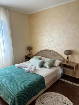 a bedroom with a bed with a green comforter at Dale apartment Becici- Paradiso in Budva