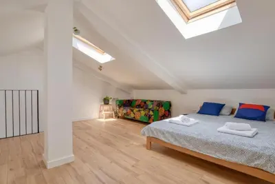 a white bedroom with a bed and a couch at Magi-Family Rooftop Apartment Budva in Budva