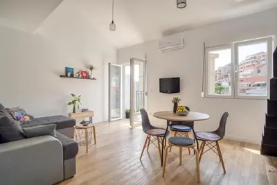 a living room with a couch and a table and chairs at Magi-Family Rooftop Apartment Budva in Budva