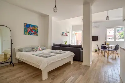 a white living room with a bed and a couch at Magi-Family Rooftop Apartment Budva in Budva
