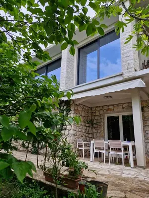 a patio of a house with tables and chairs at Garden House in Budva