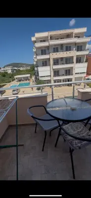 a table and chairs on a balcony with a building at Villa Pelinku in Ulcinj