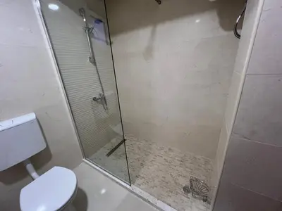 a bathroom with a glass shower with a toilet at Villa Pelinku in Ulcinj