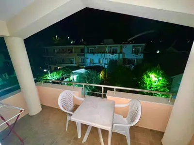 a table and chairs on a balcony at night at Villa Pelinku in Ulcinj