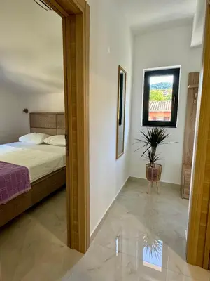 a bedroom with a bed and a potted plant at Harmony Garden Apartments in Kotor