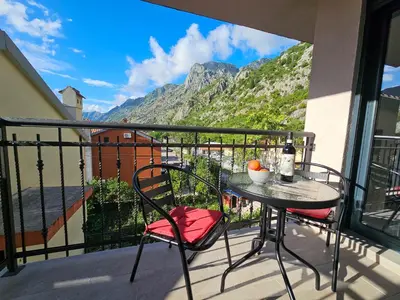 a table and chairs on a balcony with a view at Harmony Garden Apartments in Kotor