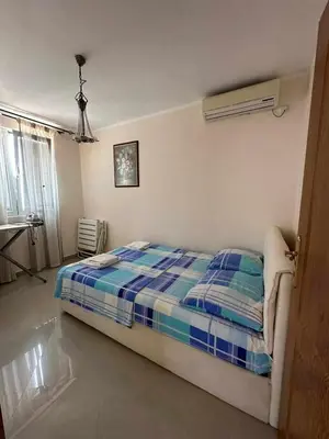 a bedroom with a bed with a blue and white blanket at Villa Noble in Dobra Voda