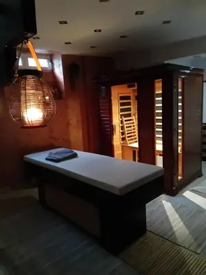 a bed in a room with a table and lights at Sleep & Spa 1 in Podgorica