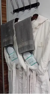 two toothbrushes and towels are hanging on a rack at Sleep & Spa 1 in Podgorica