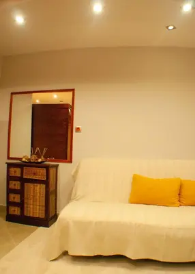 a bedroom with a bed with a yellow pillow and a mirror at Sleep & Spa 1 in Podgorica
