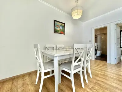 a dining room with a white table and chairs at Lenny One bedroom Apartment Sveti Stefan in Budva