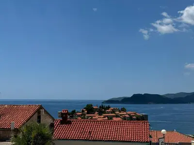 a view of roofs of houses and the water at Lenny One bedroom Apartment Sveti Stefan in Budva