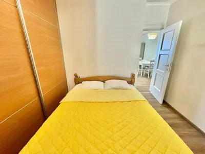 a small bedroom with a yellow bed in a room at Lenny One bedroom Apartment Sveti Stefan in Budva