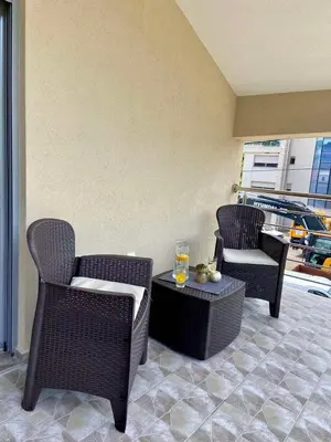 a patio with chairs and a table with a glass of wine at Apartment Victor in Kotor