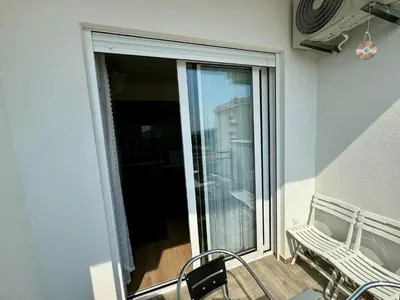 a balcony with a sliding glass door with a bench at Deluxe Apartment with Balcony and Sea View in Bar