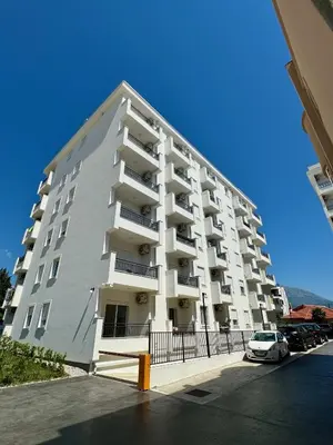 a large white building with cars parked in front of it at Deluxe Apartment with Balcony and Sea View in Bar